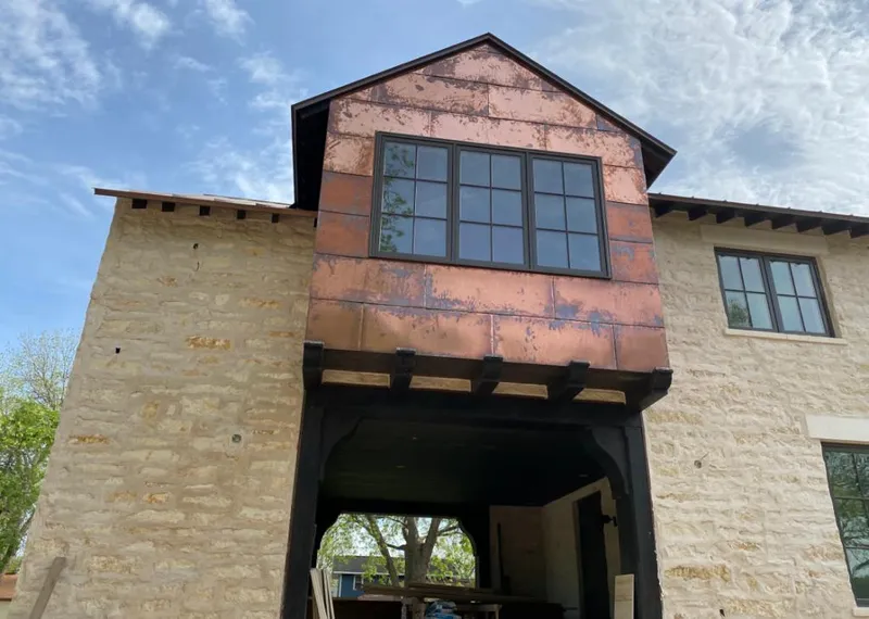 Copper metal panel facade on a stone building for Roof Repair in Lake Dallas